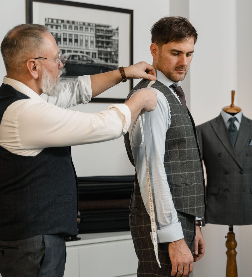 A tailor measuring a client for a made-to-measure suit